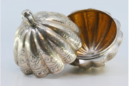 Guarda joias em prata com forma de fruta gomada com motivos florais gravados e assente em três pés.